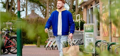 Man loopt trots met herbruikbare tas