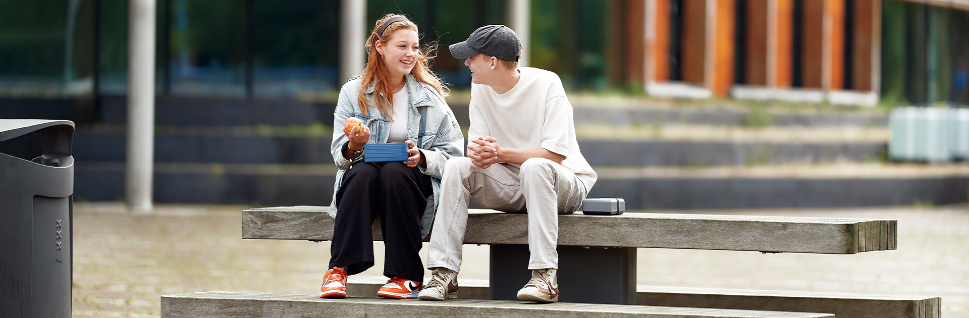 Twee scholieren op een picnicbankje met eigen herbruikbare lunchbox