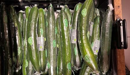 Komkommers in plastic in een winkel