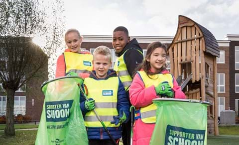 Kinderen poseren met supporter van schoon afvalzakken