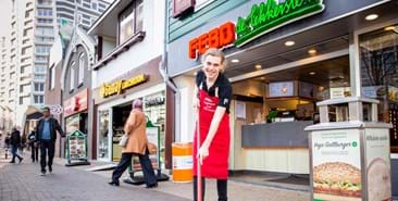 Medewerker fastfoodtent Febo schoont omgeving op