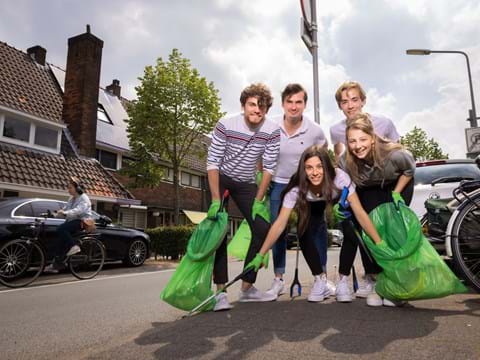 Jongeren poseren met groen afvalzakken Supporter van Schoon