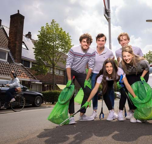 Jongeren poseren met groen afvalzakken Supporter van Schoon