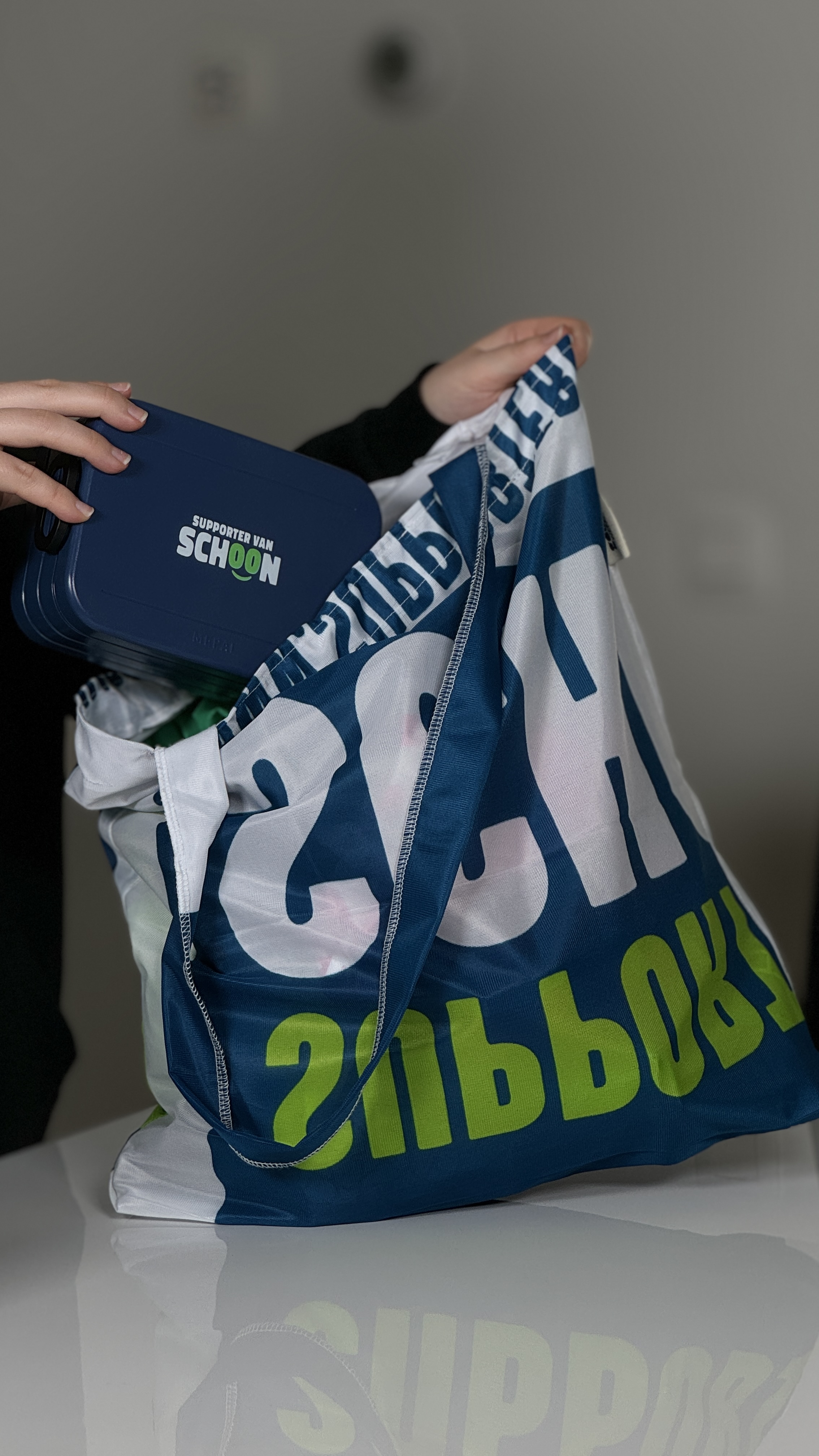 Een herbruikbare tas van stof waar een broodtrommel in wordt gestopt